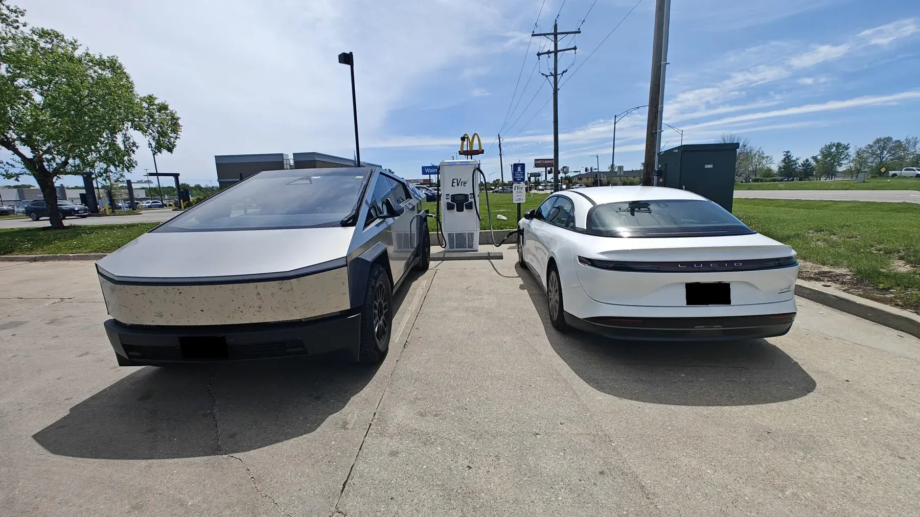 A Tesla Cybertruck and a Lucid Air charging side by side at an EVre DC fast charger