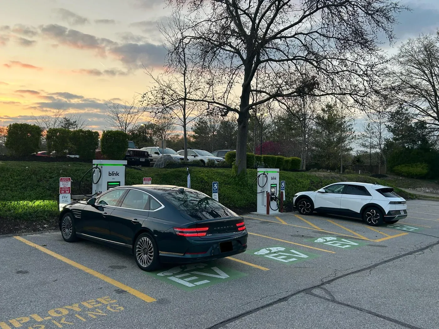 Two EVre DC fast chargers at Olympic Oaks Village at sunset with vehicles charging