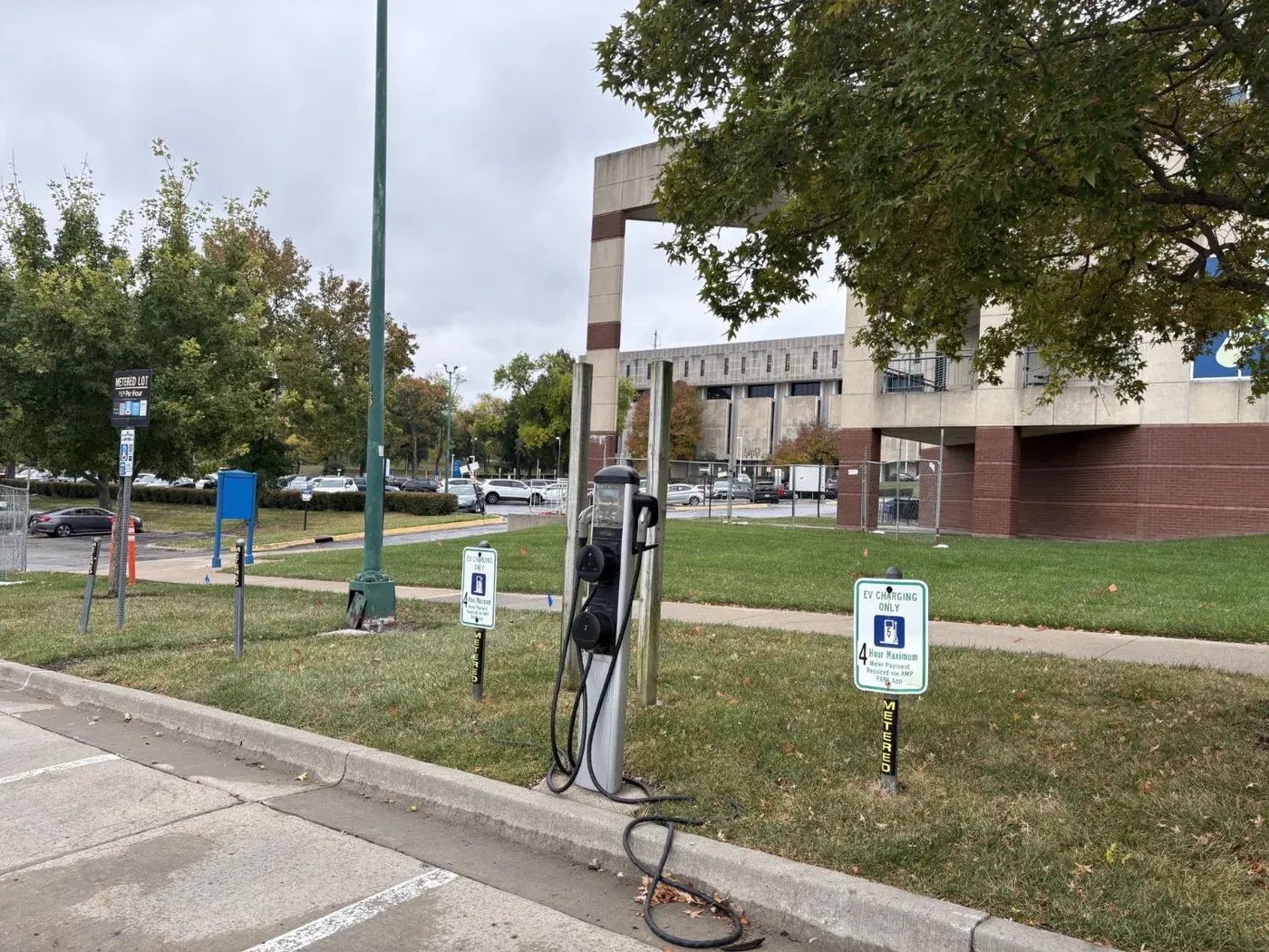 Existing dual-port Level 2 charging pedestal in a metered parking lot at UMKC's Student Success Center